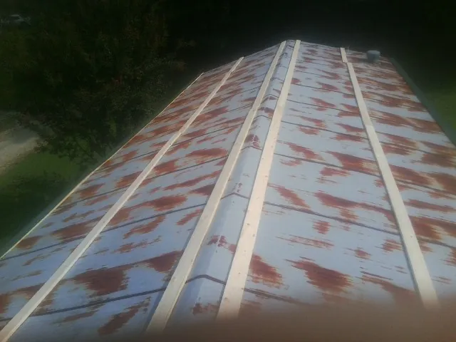 Rusted metal roof panels with new wood purlins before replacement — Storm Damage Roof Repair in Fort Myers Beach by Roofing Brothers
