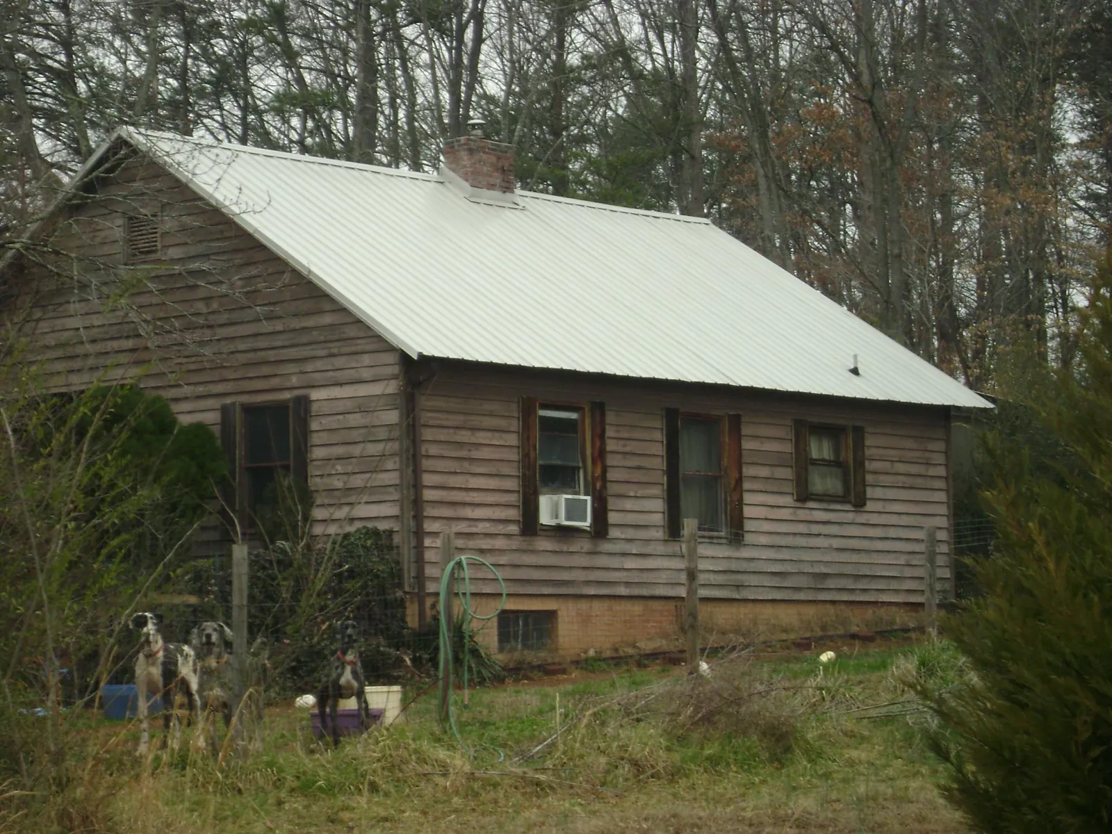 White metal roof on an old wood sided farmhouse, from a Metal Roof Installation job in Fort Myers Beach
